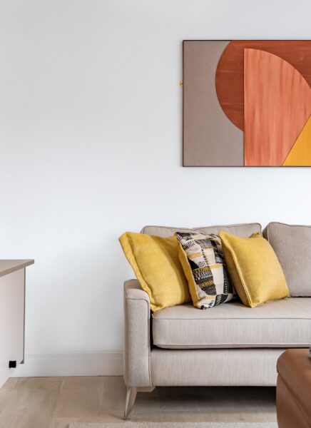 The image shows an elegantly designed modern hotel lobby featuring sleek furniture, a spacious seating area, contemporary artwork on the walls, and warm, ambient lighting.