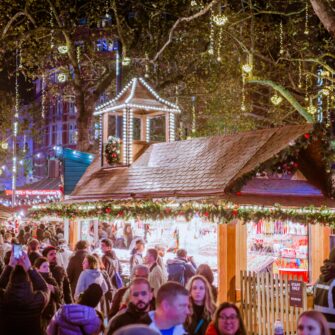 A cozy modern hotel room with a plush bed, elegant furniture, soft lighting, large window offering city views, and contemporary decor.