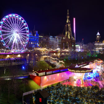 A grayscale city skyline featuring numerous skyscrapers under a cloudy sky, casting dramatic shadows and highlighting architectural features.
