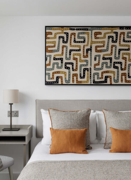 Stylish hotel room with modern art, a cosy bed, soft pillows, a sleek desk, and elegant lighting for a relaxing stay.
